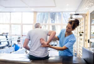 physical therapist helping a patient after back surgery