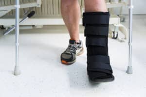 man in a walking boot after ankle replacement surgery