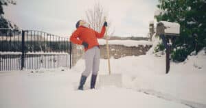person with back pain from shoveling snow